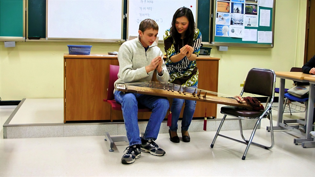 Denis is learning to play the Kayagim (or Gayagim), a traditional Korean plucked musical instrument